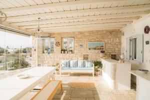 a kitchen and living room with a stone wall at Ambelas Mare Apartments in Ambelas