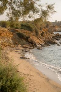 a sandy beach next to a body of water at Ambelas Mare Apartments in Ambelas