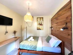 una camera con un letto con una grande testiera in legno di Cozy Bungalow Isa with AC and Generator in General Luna a General Luna