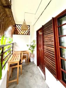 balcone con tavolo in legno e panca di Cozy Bungalow Isa with AC and Generator in General Luna a General Luna