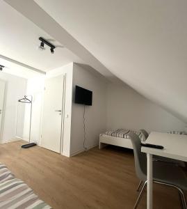 a white room with a bed and a table and chairs at Apartments zum Wildgehege in Siegen