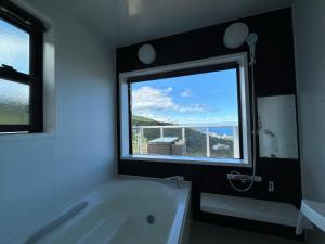 a bathroom with a tub and a large window at RetreIto Resort in Ito +7 photos