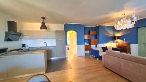 a kitchen and a living room with a couch at Villetta 56 Blu Yellow and Red Lake view Garden Private Parking by Garda Domus Mea in Tremosine Sul Garda