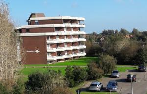 a large building with cars parked in a parking lot at Appartment 142 in Tossens in Tossenserdeich