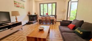 a living room with a couch and a table at Maison "La Fleur d'oranger" climatisée, classée 3 étoiles, jardin clos, box internet in Saint-Féliu-dʼAmont