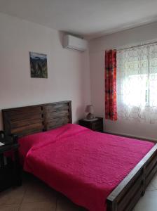 una camera da letto con un letto grande con un copriletto rosso di Combava a Saint-Pierre