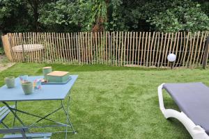 a blue picnic table in a yard with a ball at Green love & Spa - Villa Romantique in Saint-Laurent-de-Médoc