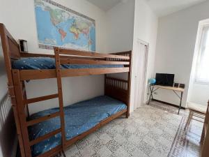 two bunk beds in a room with a desk at Trilocale a due passi dal lago La Vattutella in Marta