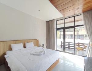 Postel nebo postele na pokoji v ubytování Oemah Tahu Banjarnegara Resto and Resort Mitra RedDoorz