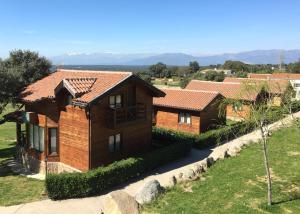 una casa en el campo con montañas en el fondo en Complejo Rural Los Jarales, en Navamorcuende