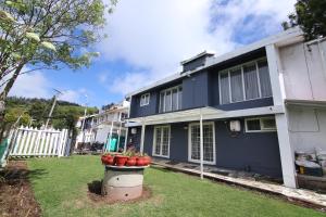 ウーティにあるTiger Hill Homestayの庭に赤い花が咲いた青い家