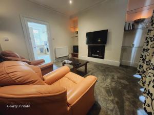 a living room with a couch and a flat screen tv at Douglas Head Road in Douglas