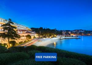 eine Stadt in der Nacht mit einem Schild, das kostenlose Parkplätze liest in der Unterkunft Remisens Hotel Epidaurus-All inclusive in Cavtat
