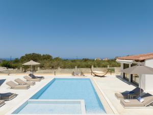 AtsipopouloにあるMaYa Villa, a sublime luxury villa close to Rethymno and all amenities!の建物の上にラウンジチェアとハンモックが置かれたプール