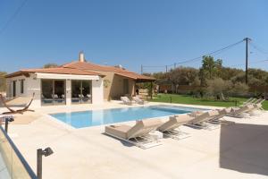 AtsipopouloにあるMaYa Villa, a sublime luxury villa close to Rethymno and all amenities!のラウンジチェア付きのスイミングプール、家