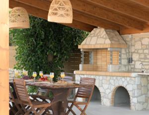 AtsipopouloにあるMaYa Villa, a sublime luxury villa close to Rethymno and all amenities!の木製のテーブルと椅子、そして石窯