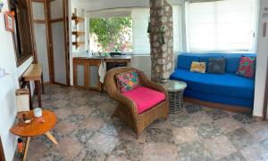 a living room with a blue couch and a chair at Hotel Gilda in Coyuca