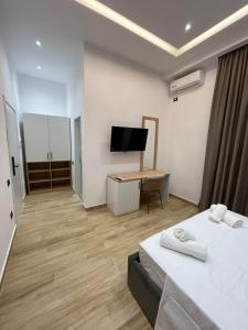 a room with a bed and a desk and a tv at Florida Rooms in Vlorë