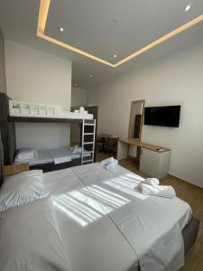 a bedroom with a large white bed and a television at Florida Rooms in Vlorë