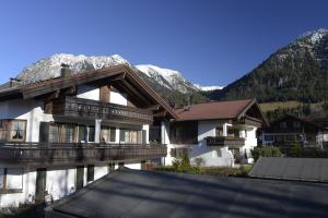 a large house with a mountain in the background at Ferienwohnung König-Denich in Oberstdorf