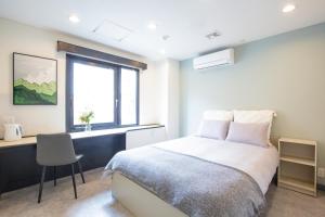 Un dormitorio con una cama y un escritorio y una ventana. en Minutes from Sumiyoshi & Iconic Attractions & Sky Tree, en Tokio 16 fotos más