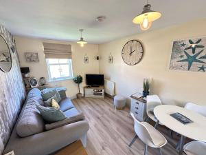 a living room with a couch and a table at Starfish Shack - Part of the The Bay Filey Holiday Village with pool, gym and direct beach access, pub, restaurant, tennis and meadows walks in Filey