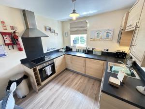 a kitchen with a sink and a stove top oven at Starfish Shack - Part of the The Bay Filey Holiday Village with pool, gym and direct beach access, pub, restaurant, tennis and meadows walks in Filey
