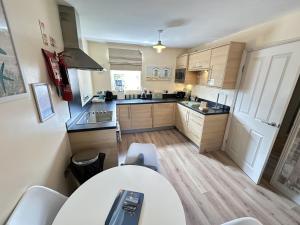 a small kitchen with a table and chairs in it at Starfish Shack - Part of the The Bay Filey Holiday Village with pool, gym and direct beach access, pub, restaurant, tennis and meadows walks in Filey