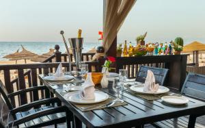 a wooden table with plates and napkins on the beach at Marhaba Royal Salem - Family Only in Sousse