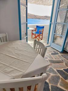 un tavolo con sedie in una camera con vista sull'oceano di Villa Elena Kythnos a Mérichas