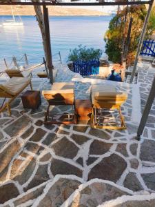 patio con tavolo, sedie e acqua di Villa Elena Kythnos a Mérichas