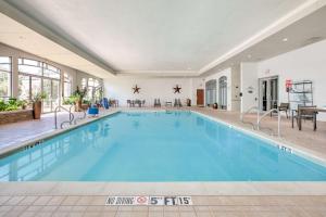 a large swimming pool with blue water in a building at Embassy Suites Dallas - DFW Airport North in Grapevine