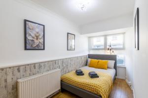 a bedroom with a bed with yellow pillows at Open Mind Property - 4 Beds 2 Bathrooms & Parking in Portsmouth +22 photos