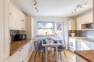 a kitchen with a table and chairs in a kitchen at Open Mind Property - 4 Beds 2 Bathrooms & Parking in Portsmouth
