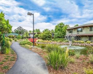 un parco con laghetto, luce di strada e fontana di Gaia Hotel & Spa, Ascend Hotel Collection ad Anderson