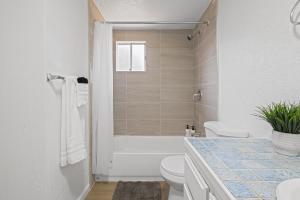 a bathroom with a tub and a toilet and a sink at # Marbella Lane - Modern Cabin-style 2BR Home in Campbell +18 photos