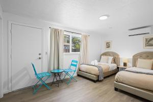 a bedroom with two beds and a table and chairs at # Marbella Lane - Modern Cabin-style 2BR Home in Campbell
