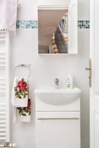a white bathroom with a sink and a mirror at Cosy House with Paris Metro Direct Champs Elysées Eiffel Montmartre in Saint-Denis