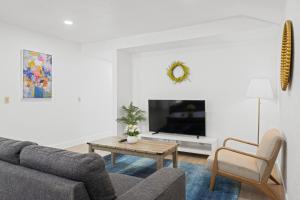 a living room with a couch and a tv at # Marbella Lane - Modern Cabin-style 2BR Home in Campbell