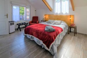 a bedroom with a bed with a red blanket and a chair at Cosy House with Paris Metro Direct Champs Elysées Eiffel Montmartre in Saint-Denis