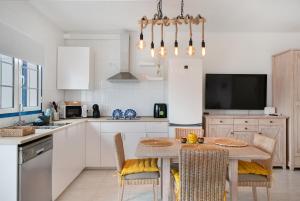 une cuisine avec une table avec des chaises et une télévision dans l'établissement Atlantic Soul, à Playa Blanca