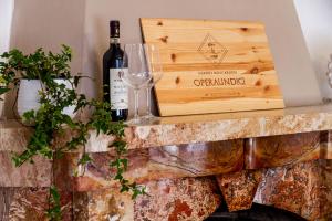 een fles wijn en een wijnglas op een open haard bij Appartamento INDIPENDENTE USO ESCLUSIVO con giardino, posto auto privato e barbecue in Cecina