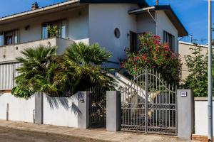 een huis met een hek ervoor bij Appartamento INDIPENDENTE USO ESCLUSIVO con giardino, posto auto privato e barbecue in Cecina