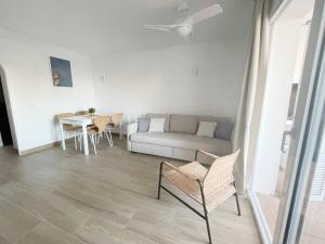 salon z kanapą i stołem w obiekcie Apartamento Lia en Port Addaia, piscina y barbacoa, perfecto para vacaciones w mieście Port d'Addaia +20 zdjęć