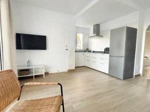 kuchnia z białymi szafkami i lodówką ze stali nierdzewnej w obiekcie Apartamento Lia en Port Addaia, piscina y barbacoa, perfecto para vacaciones w mieście Port d'Addaia