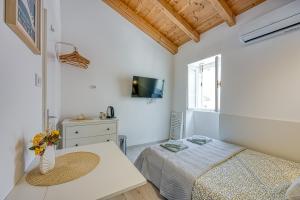 a bedroom with a bed and a tv on the wall at Lasta Lošin Town Rooms - Happy Rentals in Mali Lošinj