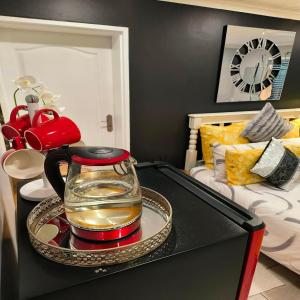 a tea kettle on a tray on a table in a room at Hidden Gem Self-catering RUWARI BRACKENFELL CAPE TOWN in Cape Town