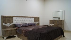 a bedroom with a large bed and a mirror at Besan Motel in As Sulaymānīyah