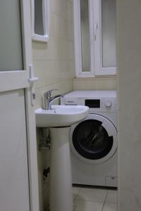 a bathroom with a sink and a washing machine at Besan Motel in As Sulaymānīyah