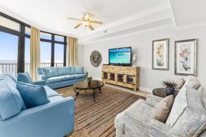 a living room with blue couches and a tv at The Oasis at Orange Beach 2203 in Orange Beach
